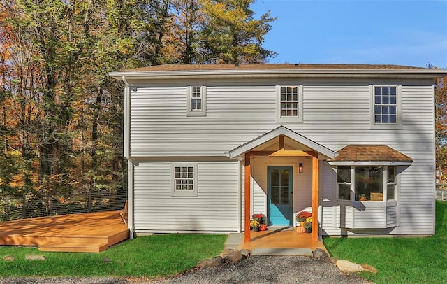 front facade featuring a front lawn and a deck