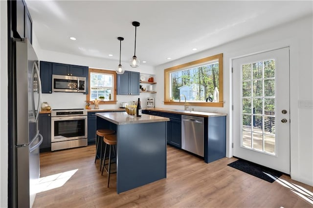 kitchen featuring plenty of natural light, a kitchen island, blue cabinets, and stainless steel appliances