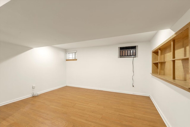 20070 39th Ave, Bayside, NY 11361 - basement with light wood-type flooring, baseboards, and a wall mounted air conditioner