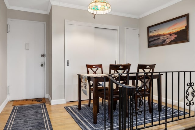 dining area with wood-type flooring and ornamental molding