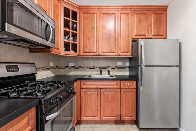 kitchen with decorative backsplash, light tile patterned floors, sink, and appliances with stainless steel finishes