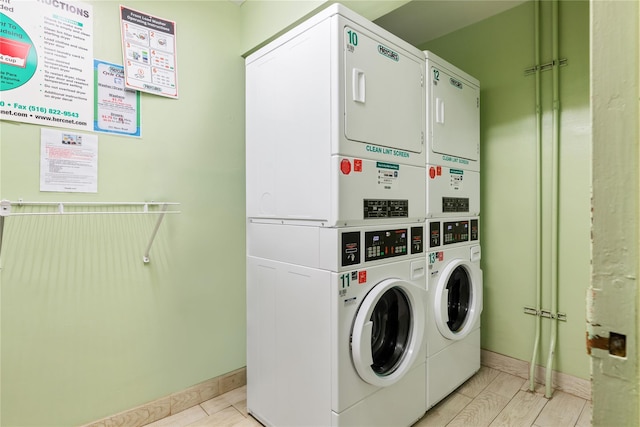 laundry room with light hardwood / wood-style floors, stacked washer / dryer, and washing machine and clothes dryer