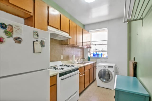 kitchen with white appliances, washer / clothes dryer, tasteful backsplash, and sink