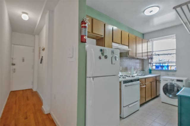 kitchen featuring decorative backsplash, white appliances, sink, washer / dryer, and light hardwood / wood-style floors