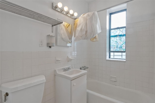 bathroom featuring a wealth of natural light, a washtub, vanity, and tile walls