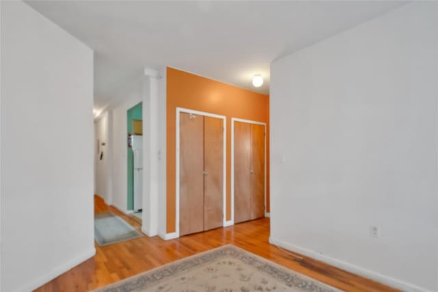 2400 Davidson Ave Unit A24, Bronx, NY 10468 - unfurnished bedroom with wood finished floors, freestanding refrigerator, and multiple closets