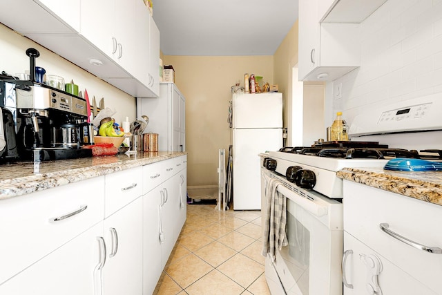 kitchen with light stone counters, white appliances, extractor fan, light tile patterned floors, and white cabinetry