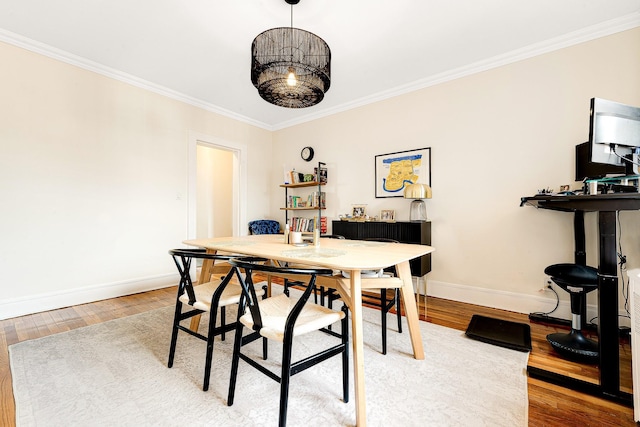 dining area featuring wood-type flooring and crown molding