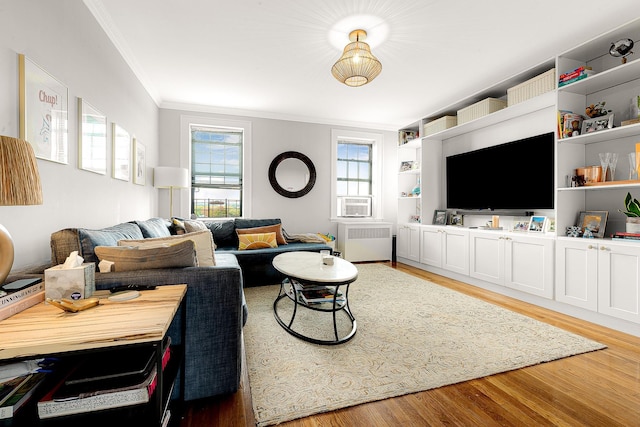 living room featuring hardwood / wood-style floors, ornamental molding, and radiator