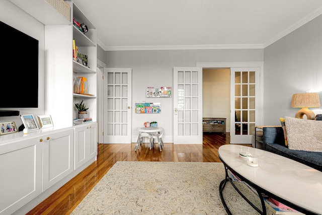 living room with hardwood / wood-style flooring, ornamental molding, and french doors