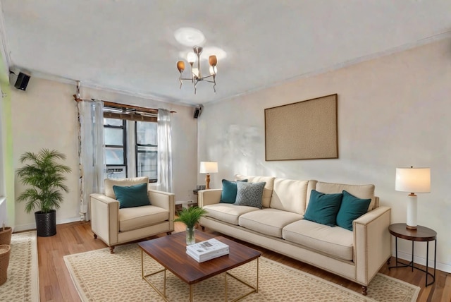 living room with ornamental molding, light hardwood / wood-style floors, and a notable chandelier