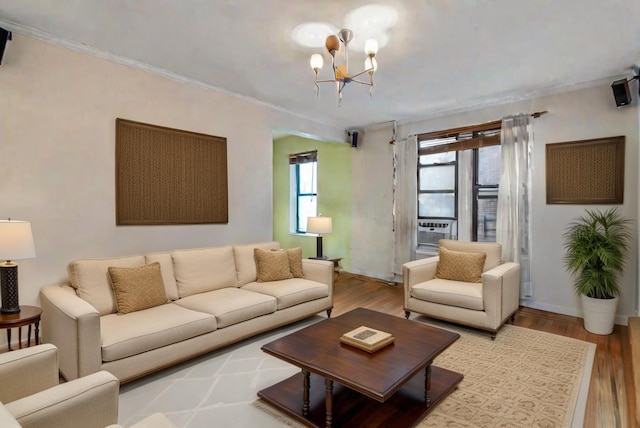 living room with a notable chandelier, crown molding, and light hardwood / wood-style flooring