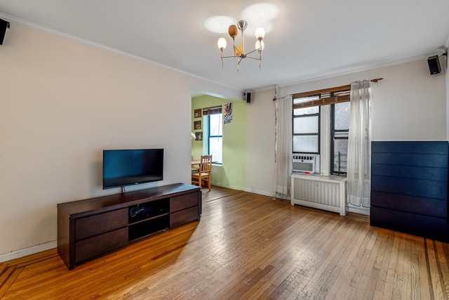 living room featuring a chandelier, light wood-type flooring, radiator, and crown molding