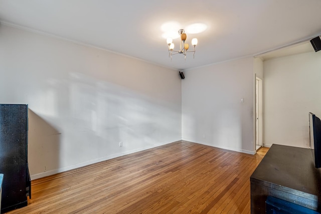 living room with crown molding, an inviting chandelier, and light wood-type flooring