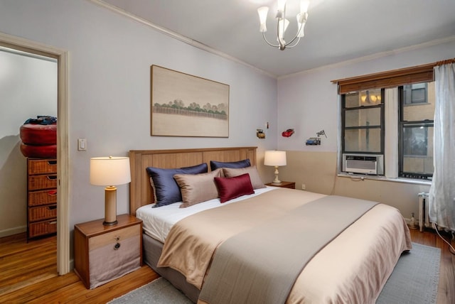 bedroom with hardwood / wood-style flooring, a notable chandelier, and crown molding