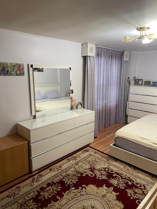 bedroom featuring light hardwood / wood-style floors and crown molding