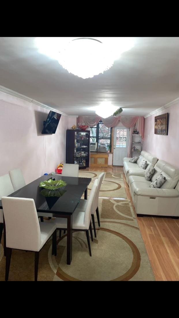 dining area with wood-type flooring and crown molding