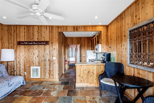 362 Ocean Walk, Fire Island Pines, NY 11782 - kitchen featuring white appliances, stone tile floors, recessed lighting, wood walls, and a peninsula