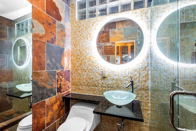 362 Ocean Walk, Fire Island Pines, NY 11782 - bathroom with tile walls, toilet, a sink, a stall shower, and decorative backsplash