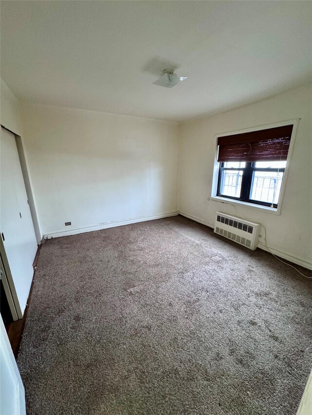 spare room with dark carpet and an AC wall unit