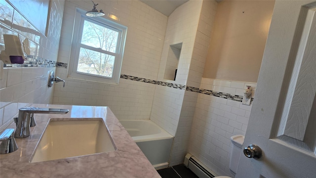 bathroom featuring sink, baseboard heating, and tile walls