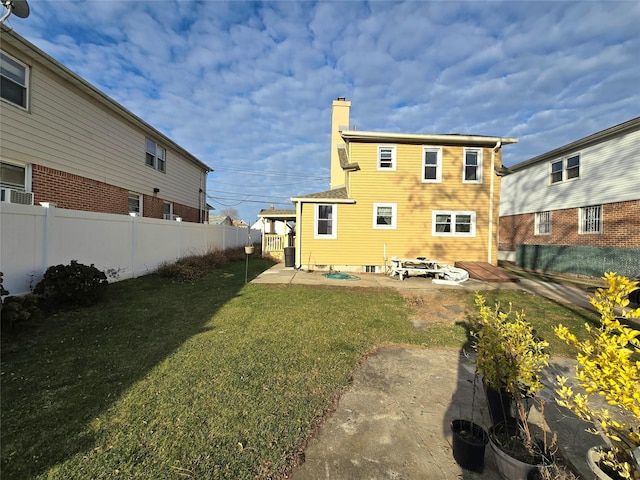 110-17 Monterey St, Queens Village, NY 11429 - rear view of property featuring fence, a lawn, a chimney, and a patio area