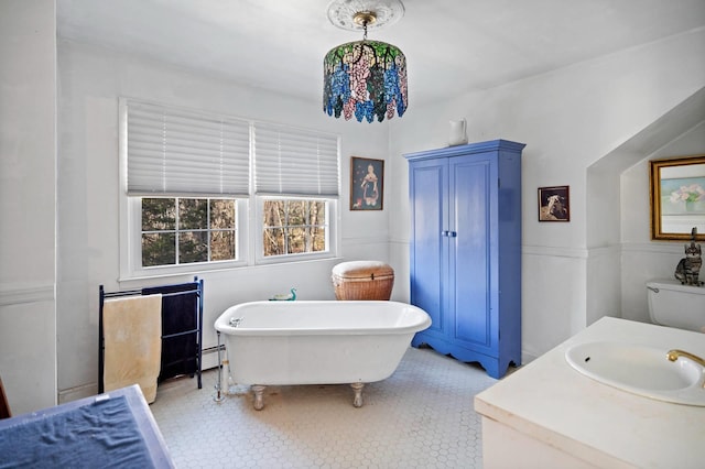 bathroom featuring vanity, toilet, baseboard heating, and a bathing tub