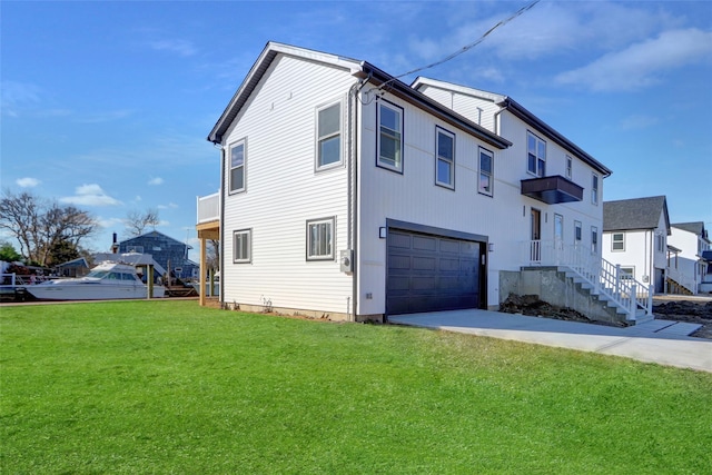 view of side of property featuring a garage and a lawn