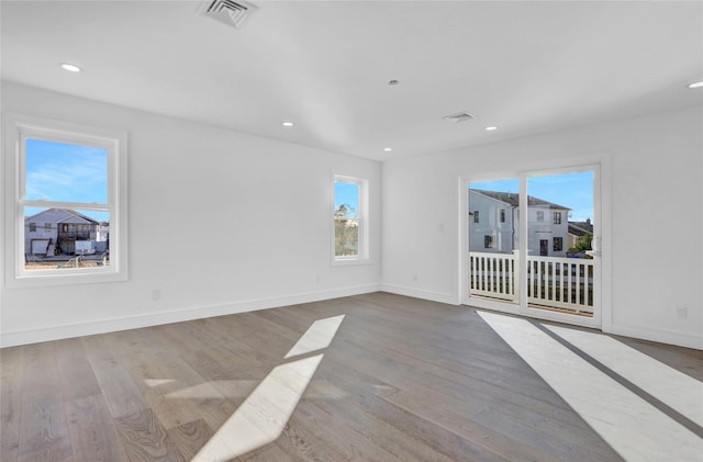 empty room featuring light wood-type flooring and a healthy amount of sunlight