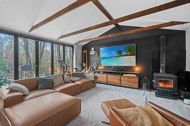 carpeted living room with vaulted ceiling with beams and a wood stove