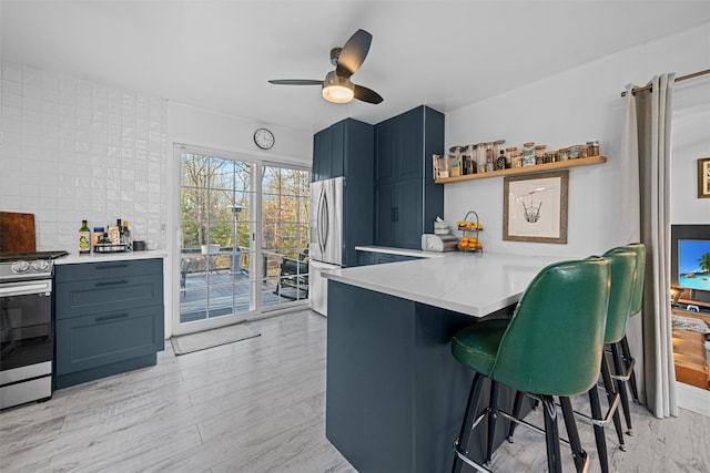 kitchen featuring light hardwood / wood-style flooring, stainless steel appliances, a kitchen breakfast bar, tasteful backsplash, and kitchen peninsula