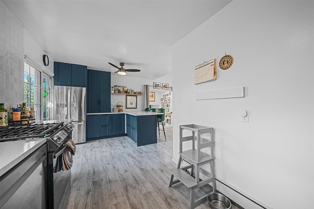 kitchen featuring black range with gas cooktop, blue cabinets, a breakfast bar area, stainless steel fridge, and light hardwood / wood-style flooring