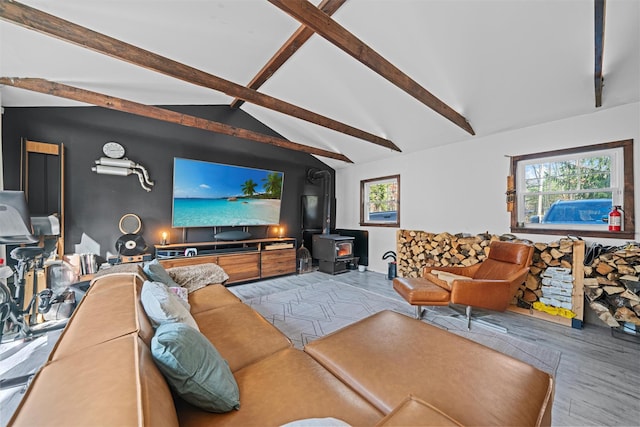 living room featuring hardwood / wood-style flooring, plenty of natural light, lofted ceiling with beams, and a wood stove