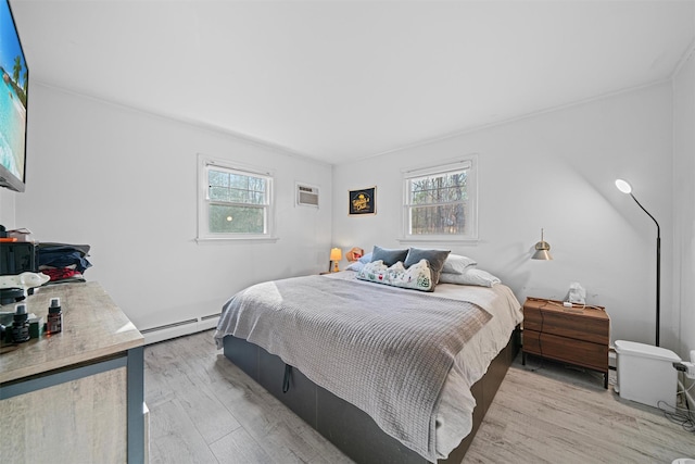 bedroom with a baseboard radiator, multiple windows, and light hardwood / wood-style flooring