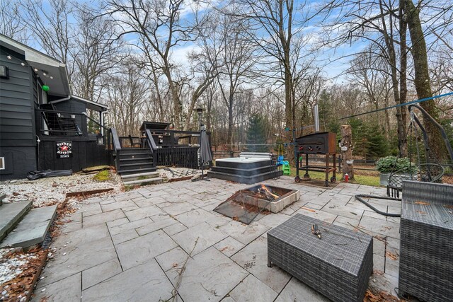 view of patio with a wooden deck and a fire pit