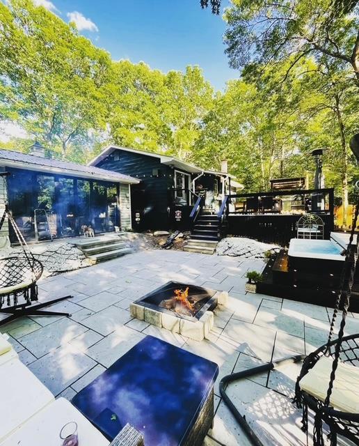 exterior space featuring a deck, a patio area, and a fire pit