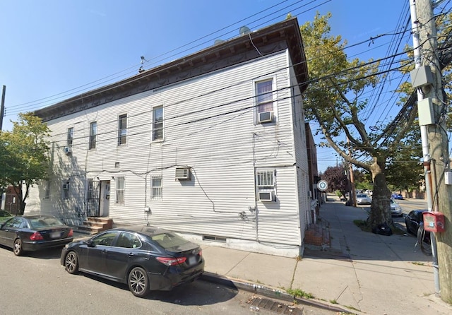 126-20 89th Ave, Richmond Hill, NY 11418 - view of side of property featuring a wall mounted AC, crawl space, and cooling unit