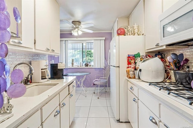 kitchen with white cabinetry, sink, ceiling fan, white appliances, and light tile patterned flooring