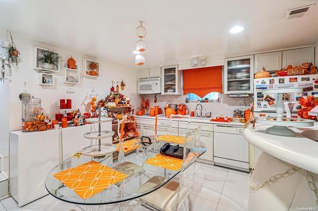 kitchen with white appliances, sink, light tile patterned floors, and tasteful backsplash