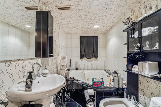 bathroom with a washtub, a bidet, and tile walls