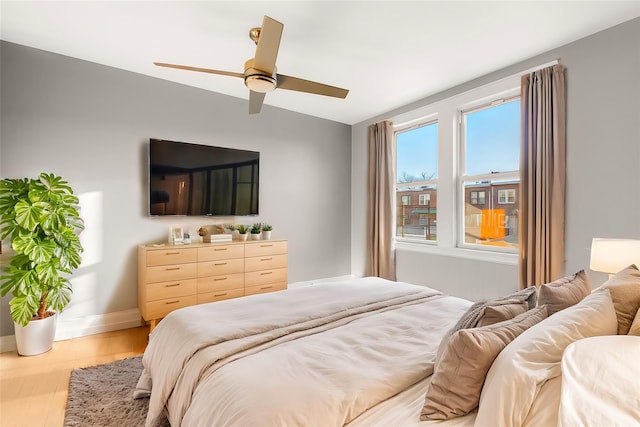 bedroom featuring ceiling fan, light hardwood / wood-style floors, and lofted ceiling