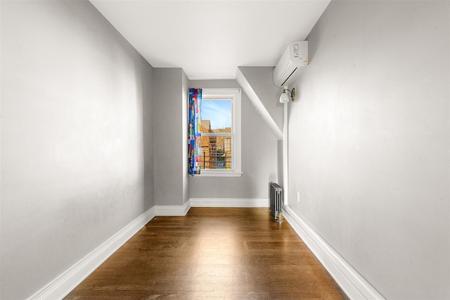 interior space with a wall mounted air conditioner and dark hardwood / wood-style floors