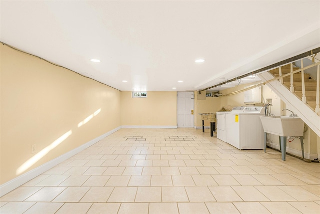 basement with washer and dryer, light tile patterned floors, and sink