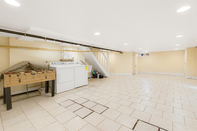 basement featuring washing machine and dryer and light tile patterned floors