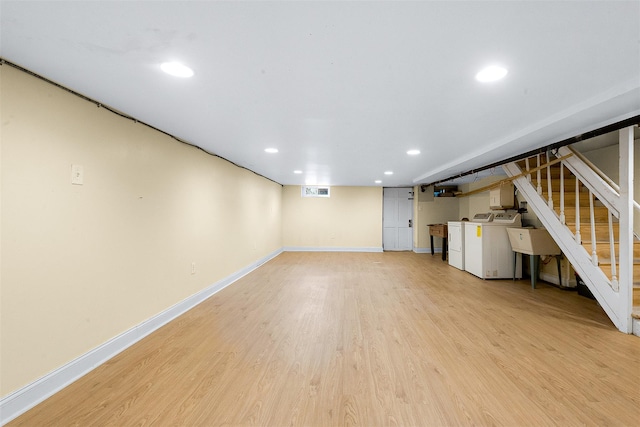 basement featuring independent washer and dryer and light hardwood / wood-style flooring