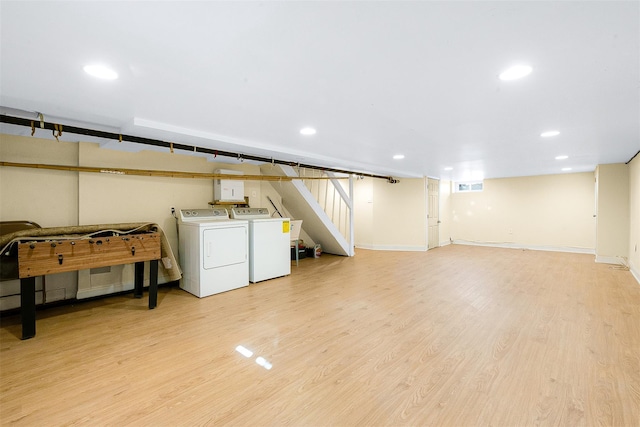 basement featuring washing machine and dryer and light hardwood / wood-style floors