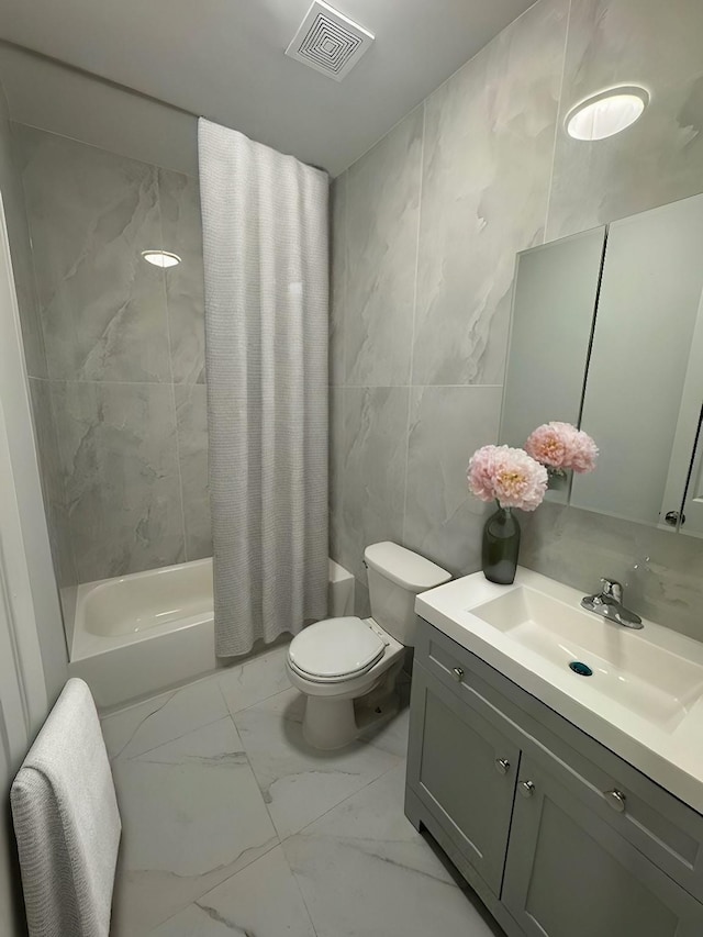 full bathroom featuring toilet, vanity, shower / tub combo with curtain, and tile walls