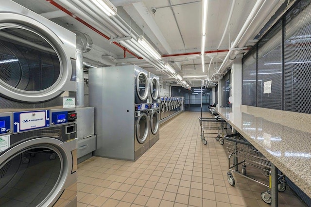 washroom with stacked washer and dryer, light tile patterned floors, and washing machine and clothes dryer