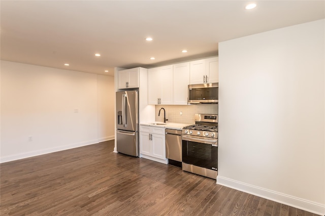 kitchen featuring stainless steel appliances, sink, white cabinets, and backsplash