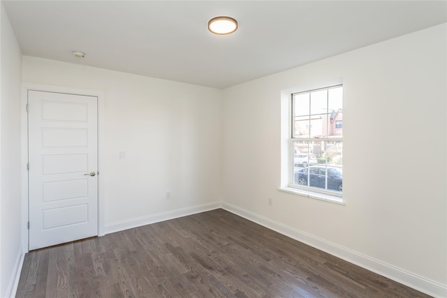 unfurnished room with dark wood-type flooring